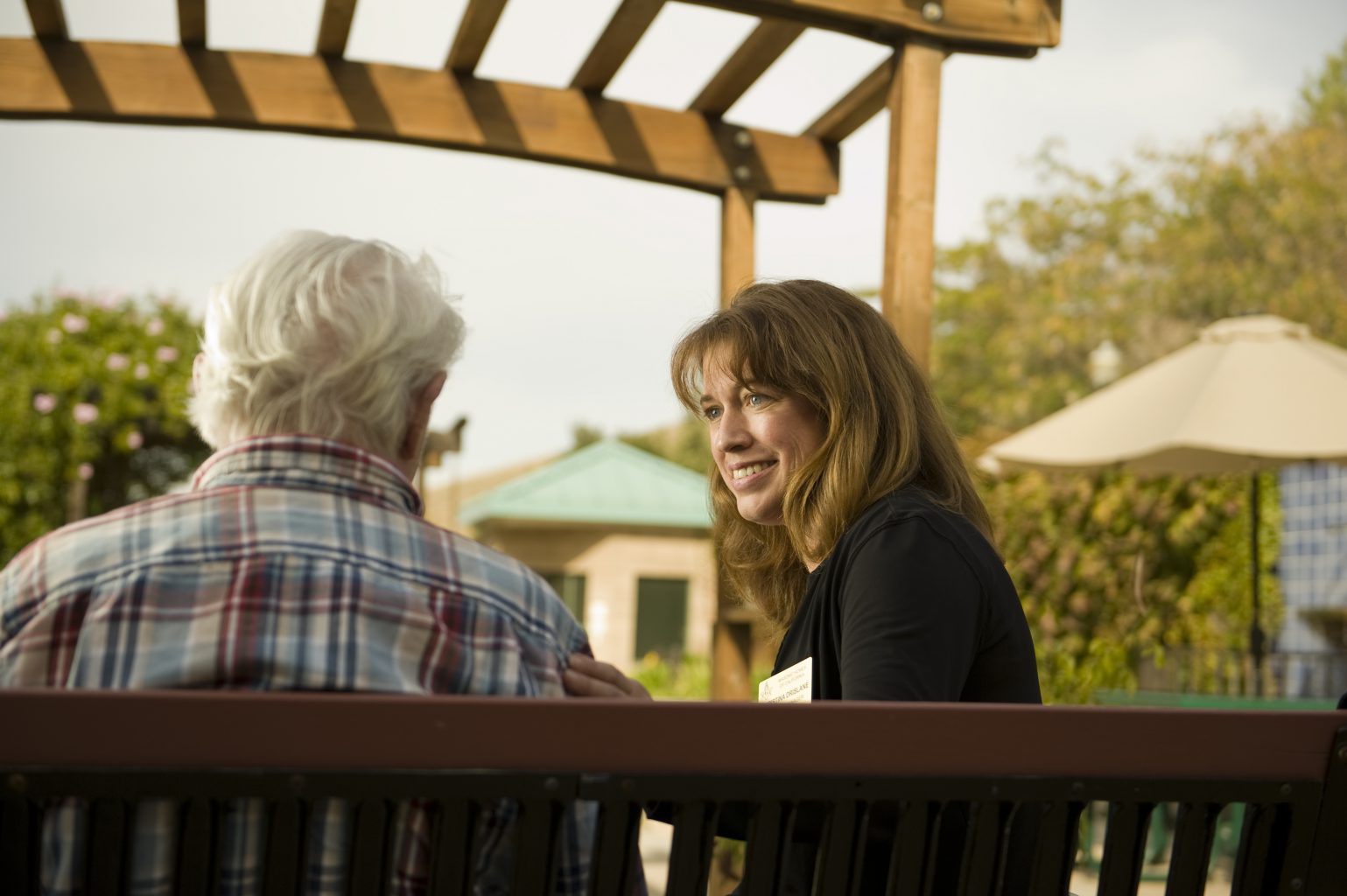 female-staff-member-comforting-male-resident-outside
